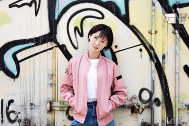 一位年轻女孩站在涂鸦墙前
