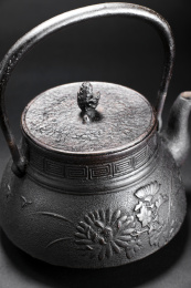 精美的铁壶的细节特写镜头，在黑色的背景里