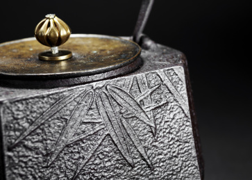 精美的铁壶的细节特写镜头，在黑色的背景里