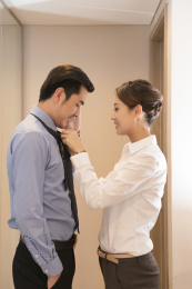 年轻女子戴上领带的年轻男子