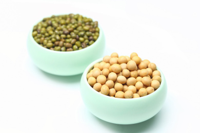黄豆和绿豆放在陶瓷小碗里,白色背景