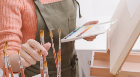艺术工作者在画室选择画笔准备绘画的特写
