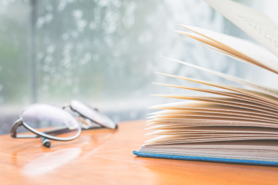 翻开的书和眼镜平放在桌子上