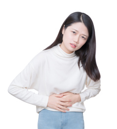 穿白色毛衣的女性手按着腹部