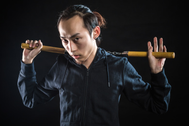 在通风橱中的亚洲男性使用双截棍上黑色隔离