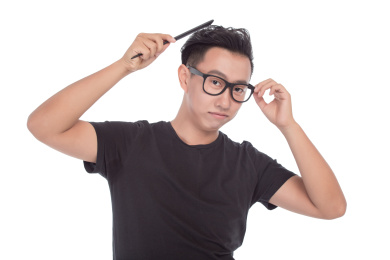 美容,修饰和人的概念 - 微笑的年轻男子梳头用梳子在灰色背景