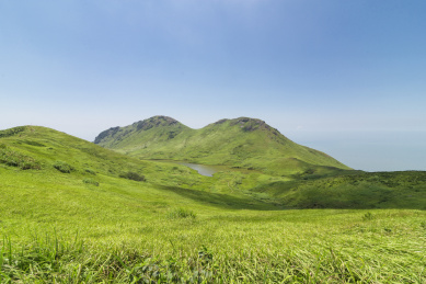 蓝天白云下的岛屿湖泊与绿油油的草场