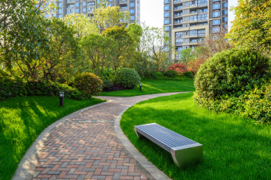 小区住宅里弯曲的步行道,砖路边绿色草坪,园林景观设计