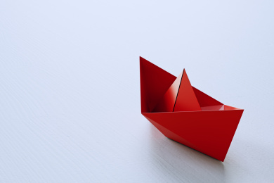 领导的概念，红色折纸船领先白色船。