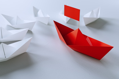 领导的概念，红色折纸船领先白色船。