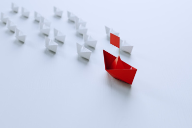 领导的概念，红色折纸船领先白色船。