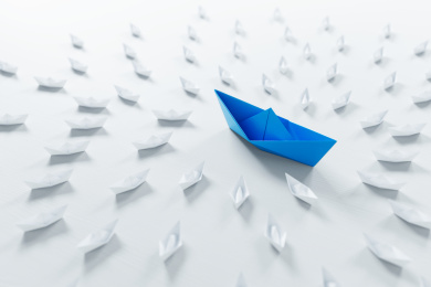 领导的概念，红色折纸船领先白色船。