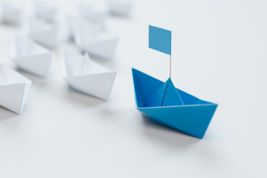 领导的概念，红色折纸船领先白色船。