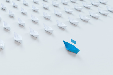 领导的概念，红色折纸船领先白色船。