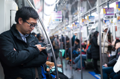 男人在地铁里玩手机