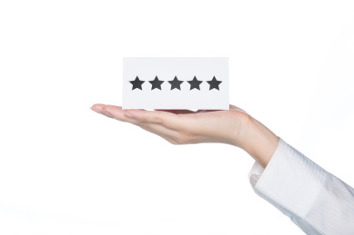 女子手拿着五星形状卡在白色背景，一流的服务