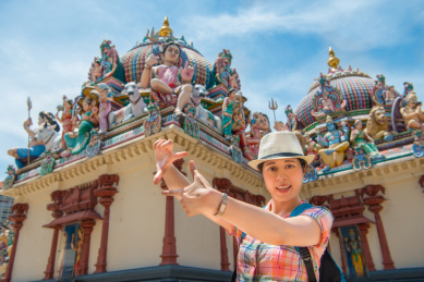 快乐的年轻女子亚洲取景的印度庙，新加坡