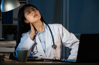 疲惫的女医生拿着后颈强调背部疼痛。美丽的混血亚洲的中国女人模型