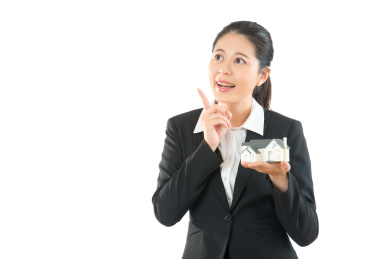 美丽的亚洲女子指着想法隔绝在白色背景。真正年轻的职业经理人有关于房子的好消息。