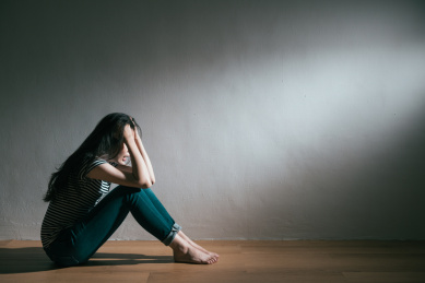 年轻漂亮的女人抑郁症破的爱情坐在木地板上哭泣和悲伤感在白色的墙壁背景的尖叫。