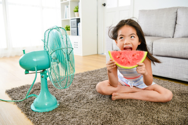 开朗的美少女小孩吃西瓜，夏天吹电扇。