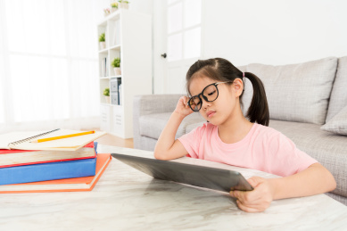 极具吸引力的小女孩在寻找电子学习网上教学视频度假的感觉无聊时在家学习。