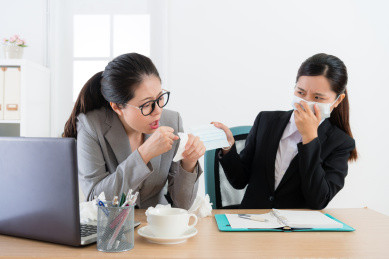 有吸引力的美少女公司员工有疾病问题咳嗽和女同事提供，以避免传染给她佩戴外科口罩。