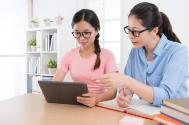 使用移动数字平板电脑学习和家庭教师辅导通过网上电子学习系统搜索她的学校工作信息幸福的年轻女生。