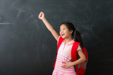 漂亮可爱的女小孩儿准备回学校隔离在黑板背景。