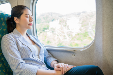 努力工作，美丽的亚裔女商人承担为她日后的旅程移动的列车舒适的睡眠。