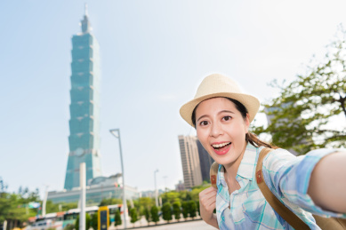 现代时尚年轻的亚洲女孩在她的网站介绍台北最高的建筑。还考虑到关于社交网络的实时视频。