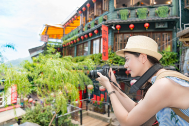 漂亮的女孩享受台湾的旅游度假，并采取著名的地标阿妹茶房子的照片。