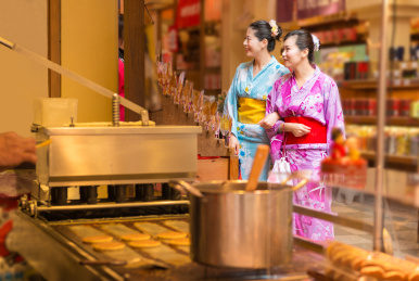 女性旅游礼服和服走在大街上的日本旅游。亚洲暑假期间食街亚洲女朋友。传统的日式休闲美食街小吃在露天市场出售。