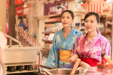 日本女性选择在大排档前，在食品街在日本的休闲美食街小吃。美亚裔女友旅行度假期间穿着传统和服。