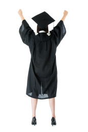 年轻美丽大学生的女孩穿着白色背景上的毕业服装的地位和显示举手庆祝整理正在学隔绝在白色背景。