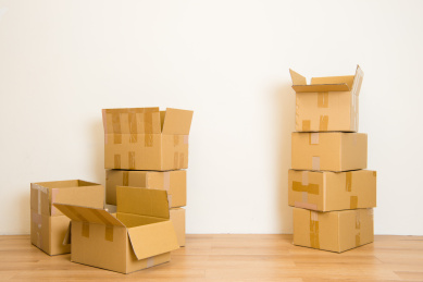 移动堆栈的纸箱在空房间的公寓中的副本空间