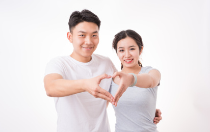一对年轻的夫妻用手比划出一个爱心