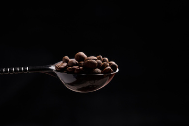一勺咖啡豆在纯黑色背景中