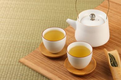 两杯热茶和一杯茶壶摆放在干净的木桌上