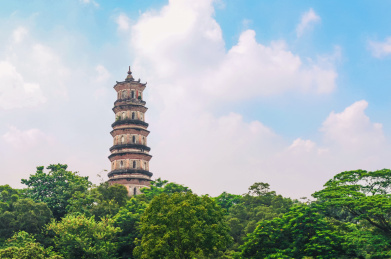 蓝天下的惠州西湖雷锋塔被绿树包围