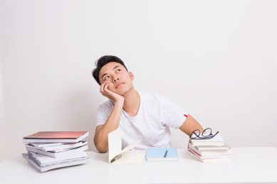 充满想象力的一个年轻大学生，坐在桌子前发呆