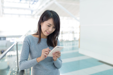 woman using mobile phone in departure hall