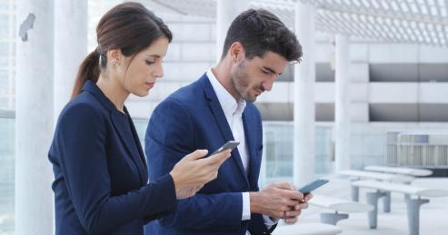 business man and businesswoman using smart phone together for