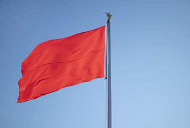 pole with raised red flag  symbol of danger for