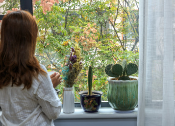 一个女性站在窗前望着窗外