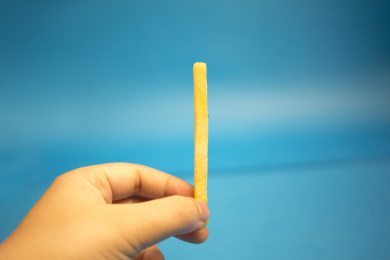 手里拿着一根薯条 黄色