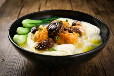 木桌上一碗汁香汤浓的蘑菇炖鸡面