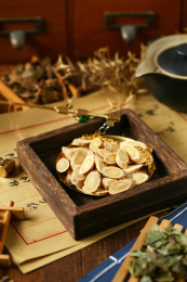 中医中草药和小铜秤放在手写毛笔字药方背景上