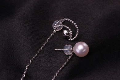 珍珠银饰耳环放在黑色的背景中