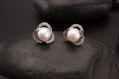 珍珠银饰耳环放在黑色的背景中